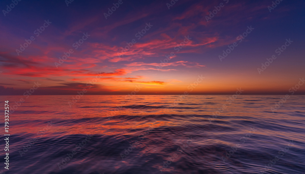 Fototapeta premium Ocean waves reflecting vibrant sunset colors under a twilight sky.