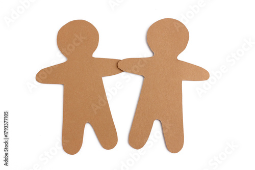 Two gingerbread men shapes cut from brown cardboard holding hands isolated