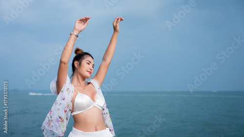 Quadro su tela Beautiful woman relaxing on yacht with blue sea background, wearing white bikini and floral shawl under sunlight