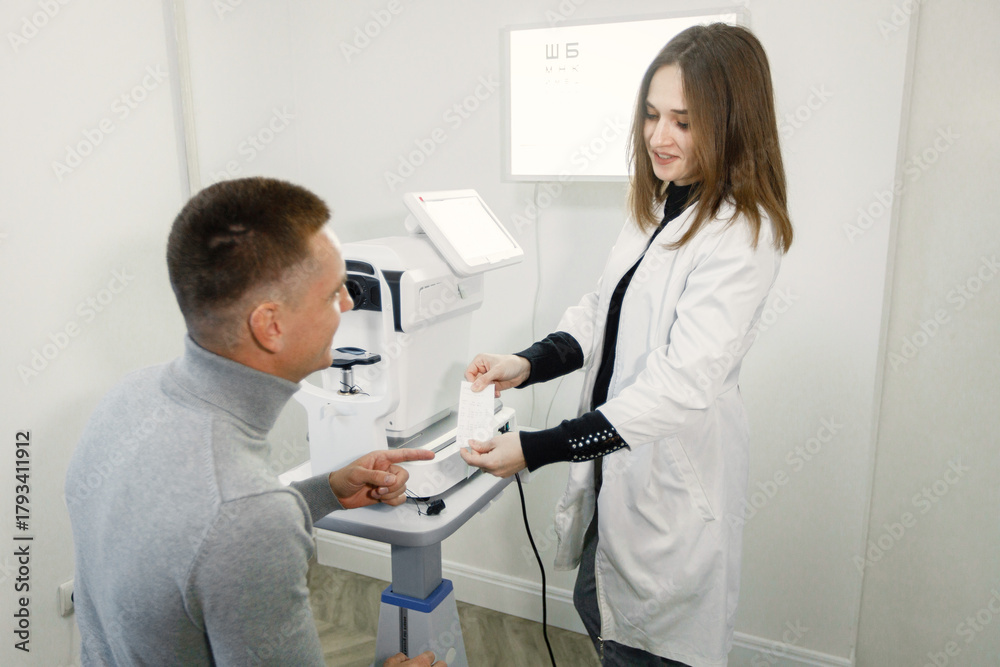Fototapeta premium Man doing eye test checking examination with optometrist