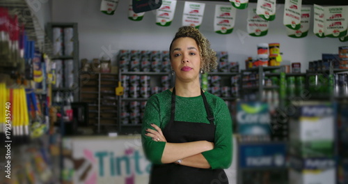 Fotografie Determined hardware store manager with arms crossed, surrounded by shelves of to