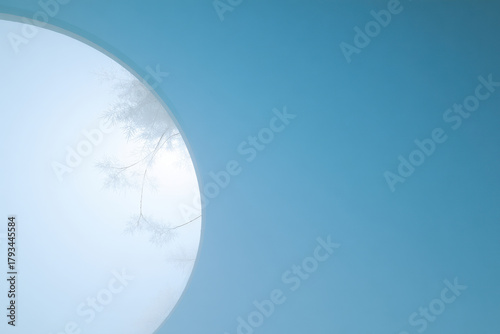 minimalist composition of delicate snowflakes enclosed in circle against clean blue sky