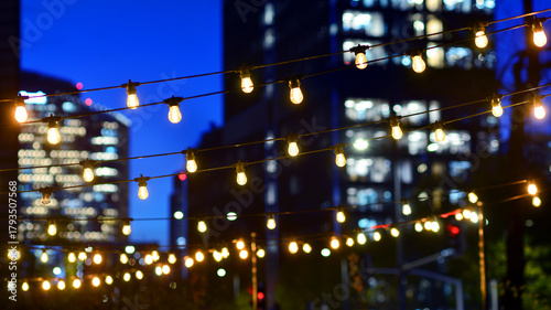 Wallpaper Mural Light bulbs garlands against glass modern buildings background in night. Blurred rows of lit windows out the architectural grid of a modern facade. Torontodigital.ca