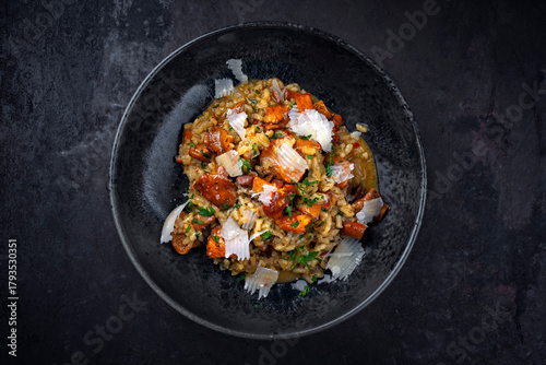 Traditional Italian risotto con finferli with fresh chanterelles and parmesan served as close-up in a Nordic design bowl