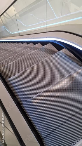 Modern empty escalator with led lights moving upwards