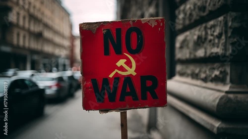 Protest sign with no war message and communist symbol held on a city street expressing antiwar sentiment activism and social movement
