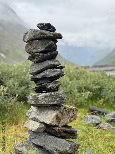 serene cairn amidst misty mountain scenery, rock formation serving as calming trail marker in wilderness