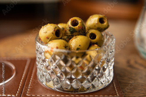 Marynowane zielone oliwki w szklanej miseczce Marinated green olives in a glass bowl