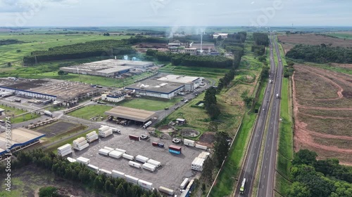 A sprawling industrial complex featuring a highway, storage containers, and warehouses