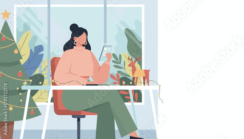 A woman works on a tablet at a festive desk decorated with a Christmas tree and holiday lights