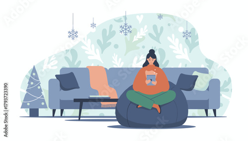 Woman relaxing on beanbag with tablet in cozy festive winter living room