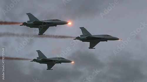 Bottom-view cinematic video of a trio of fighter jets flying in synchronized formation, engines glowing softly, sky illuminated by golden hour light
