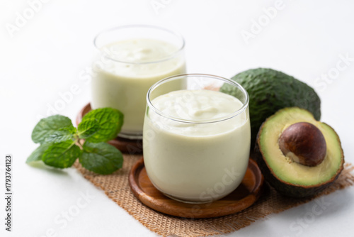 Avocado smoothie with milk in glass and avocado fruit on white background, Healthy drink