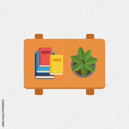 Overhead view of a rectangular wooden table with a stack of colorful books and a green potted plant.