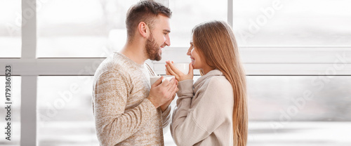 Happy couple with cups of h...