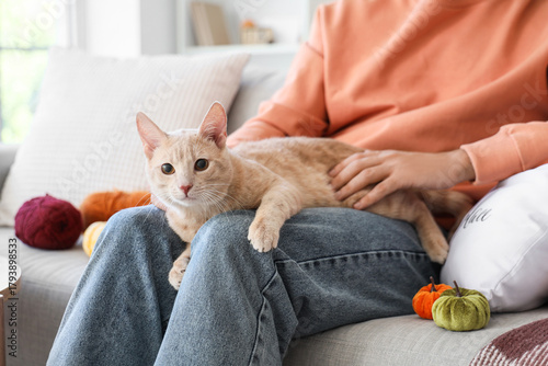 Young man with cute cat sit...