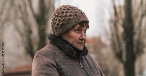 Cuadro en lienzo Elderly woman reflecting thoughtfully in urban park during a cool afternoon in e