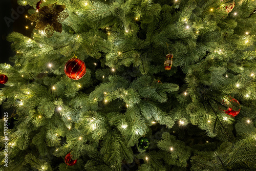 Close-up of a Christmas tree decorated with twinkling lights and colorful ornaments, creating a festive and joyful holiday mood.