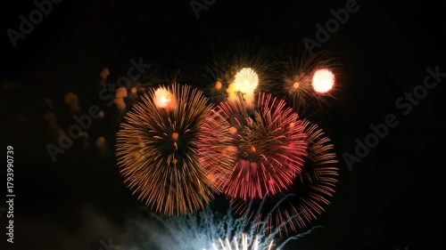 Golden fireworks illuminate the night sky with vibrant bursts of color