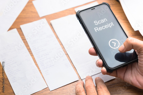 Hand using smartphone to scan and photograph receipts for budgeting, expense tracking, and tax deduction