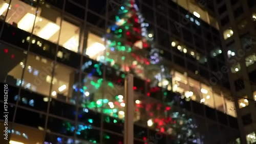Blurred view of a decorated christmas tree in front of a building at night