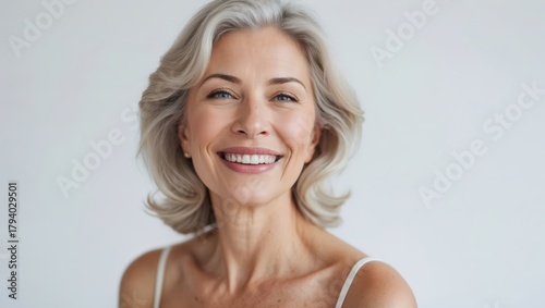 Beautiful gorgeous 50s mid aged mature woman looking at camera isolated on white. Mature old lady close up portrait. Healthy face skin care beauty, middle age skincare cosmetics, cosmetology concept