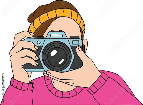 Person Wearing A Yellow Beanie And Pink Sweater Holding A Camera To Take A Photo Against A White Background