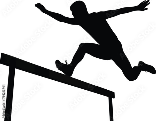 Athlete powerfully leaps over hurdle in silhouette during competition