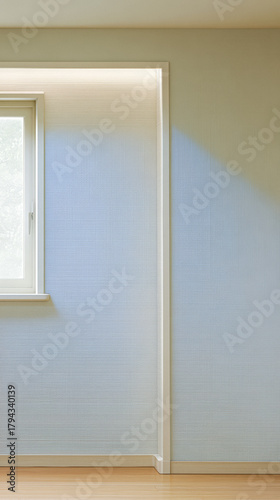 Light creates a soft ambiance in a minimalist room with a window and pale blue textured walls during daytime