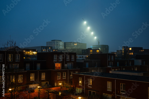 Wallpaper Mural Tall crane with lights over houses in  twilight Torontodigital.ca