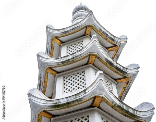 Close up of a detailed multi-tiered white pagoda structure with golden accents and intricate latticework against a stark black background showcasing architectural detail and texture
