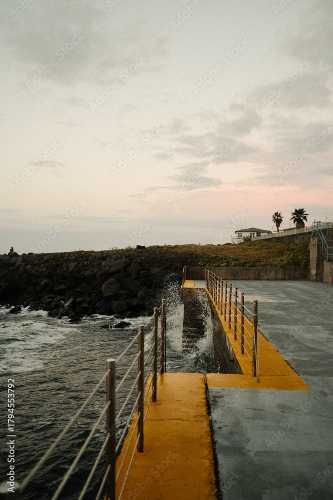 Fototapeta premium Calm ocean scene with ancient railing and mellow clouds