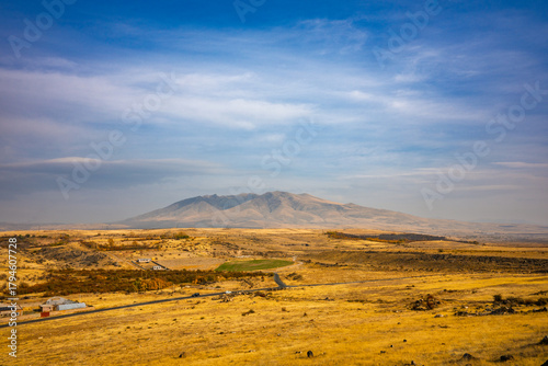 A large mountain is in the background of a dry, barren landscape