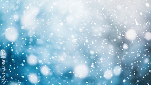 Soft snowflakes fall gently against a serene blue background creating a tranquil winter atmosphere perfect for holiday and seasonal themes