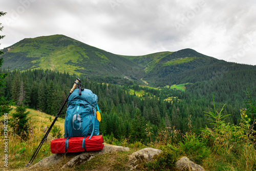 Summer hiking in the mountains with a backpack and a tent. Beautiful mountain landscape.