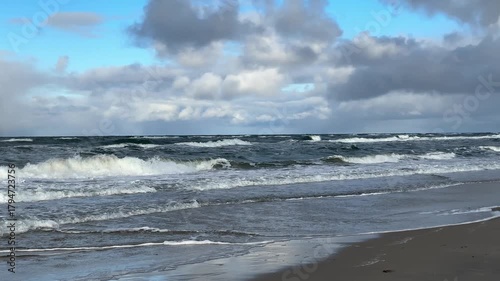 Sunny windy Baltic Sea coastline with waves, dunes and bright sky