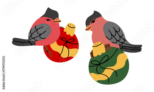A pepper and salt shaker in the form of two pink bullfinches sitting on red and green New Year's balls. Earth-themed tableware. For festive greeting cards and nature-themed celebrations