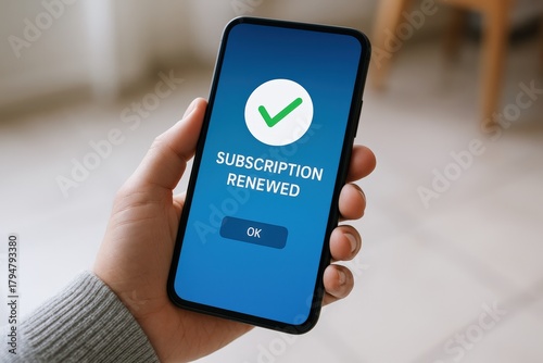 Hand holds smartphone displaying a bright blue screen with a green checkmark confirming successful subscription renewal, highlighting digital convenience and satisfaction