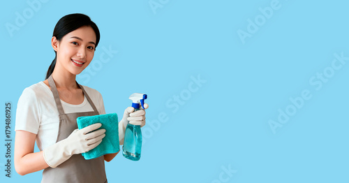 A smiling young Asian woman in gloves holds a spray bottle and a cleaning cloth. The cleaning banner has an empty space for the text.