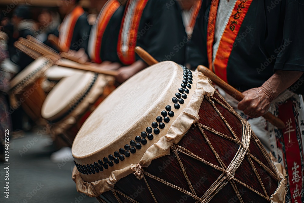 Fototapeta premium Performers rhythmically beat traditional drums, showcasing cultural celebration through vibrant music