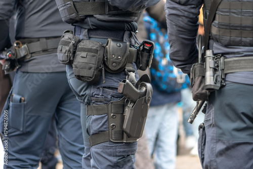 Photography Police officers are standing nearby on the street with tactical equipment and holsters placed on their belts
