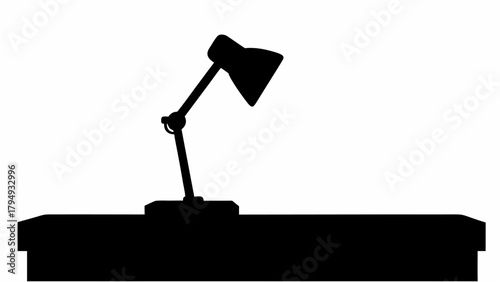 Silhouette of a desk lamp on a desk providing focused illumination in a minimalist black and white scene