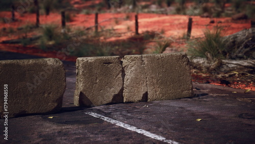 Photos A lonely road in the Australian outback is blocked by a row of large stones