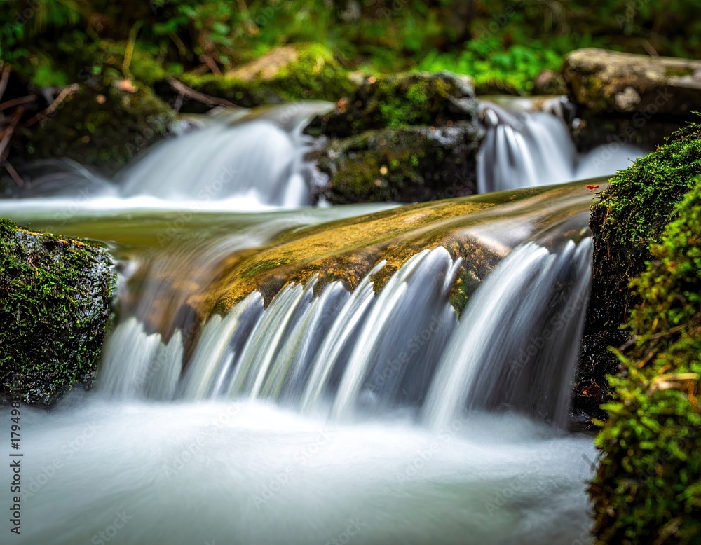 Obraz premium Serene Waterfall Cascading Over Mossy Rocks