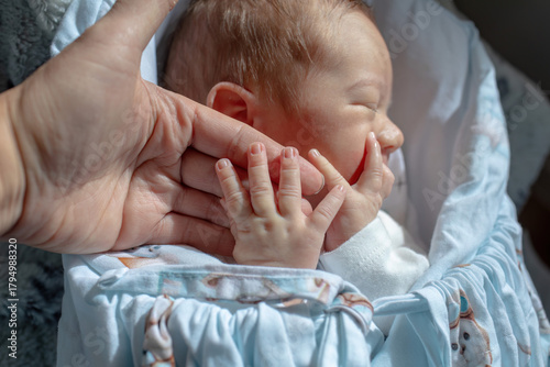 Parent holding hand of newborn baby
