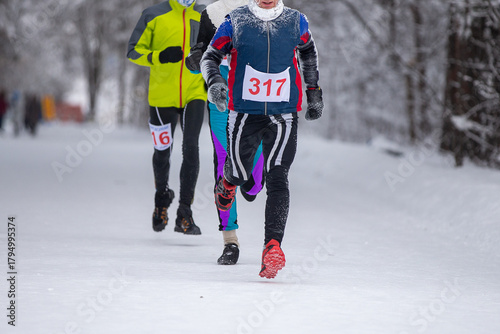 Three runners athletes runnning marathon in winter park