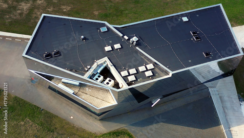 Modern building roof design featuring angular architecture and solar panels, viewed from above