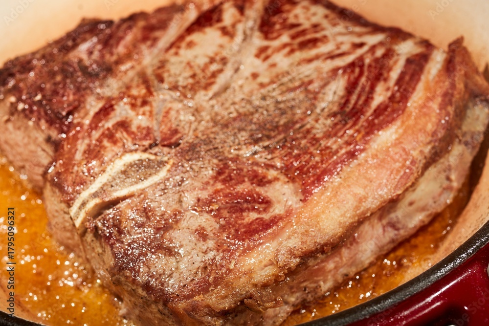 Obraz premium A chuck steak browing in a Dutch oven