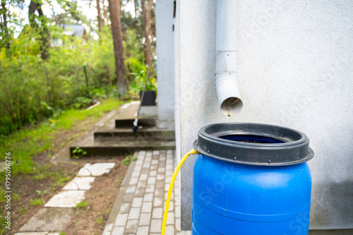 Canvas Print Large barrel with drainage stands beneath downspout beside private house, formin