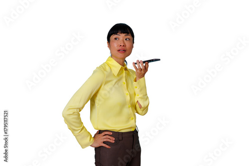 Fotografie Asian business woman dictating a voice note into her mobile phone, staying conne